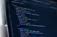 Dark code editor with colorful source code on a computer monitor